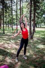 Woman exercising with elastic band outdoors 