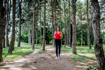 Fototapeta na wymiar Young sporty woman jogging through the forest