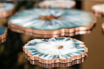 Cup holder, epoxy resin tray, black top, reflection, nautical style. Blue paint spots, gold trim. Theme for table setting. Shine, reflection.