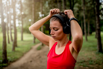 Young woman tying her hair back before a park run 