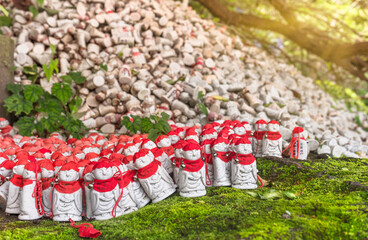 Thousands of amulets of Buddhist guardian deity of hell Jizō bosatsu wearing a cap and a red bib...