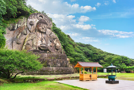 Side angle view of the largest stone-carved magaibutsu statue of giant buddha Daibutsu Yakushi of Nihonji temple on the mountain sides of Mount Nokogiri stone quarry.