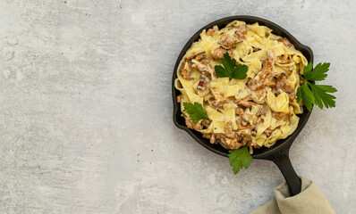 Italian pasta Tagliatelle with chanterelle mushrooms in a iron skillet pan with parsley 
