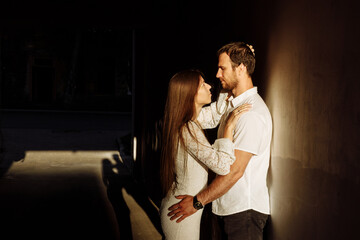 A guy and a girl hug in the light.