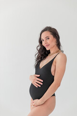 A fashion stylish pregnant sexual woman in Vogue style.glamorous Pregnant in a black bodiesuit