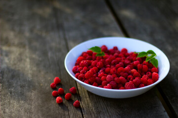 Red fresh raspberries in a white misk on a wooden background with copy space.
Healthy snack. Summer healthy food concept. Healthy organic sweet fruits.