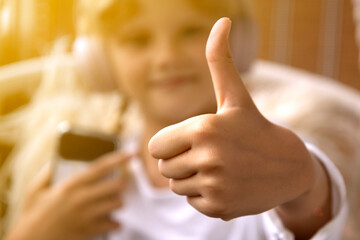  Girl in headphones shows thumbs up