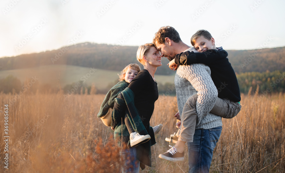 Wall mural Beautiful young family with small children on a walk in autumn nature.