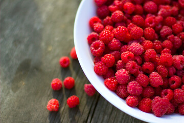 Red fresh raspberries in a white misk on a wooden background with copy space.
Healthy snack. Summer healthy food concept. Healthy organic sweet fruits.