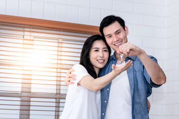 Portrait images of Asian couple, The husband is delivering the house key to his attractive wife as a gift for starting a family together, to people and relationship concept.