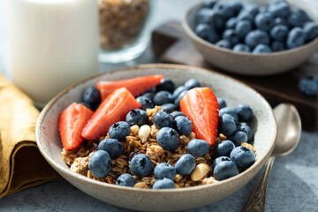 Honey granola with blueberries and strawberries in a bowl, healthy breakfast food