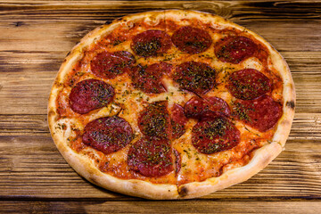 Pizza with salami sausage and parmesan cheese on a wooden table