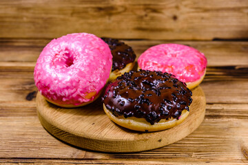 Cutting board with glazed donuts on a wooden table