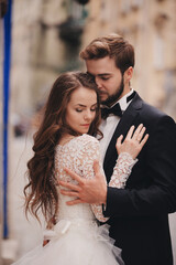 Wedding couple hugging in the old city. Blue vintage doors and cafe in ancient town on background....