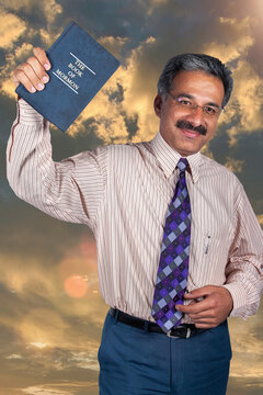 smiling man holding the book of Mormon