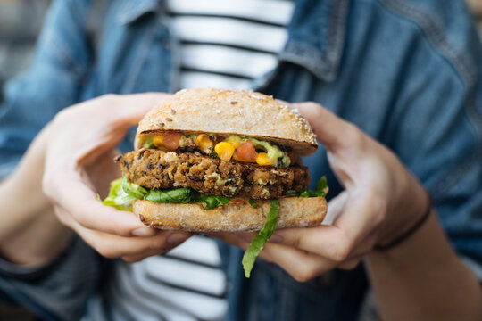 Crop woman holding vegetarian burger