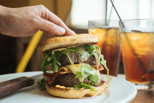 Crop hand pressing burger