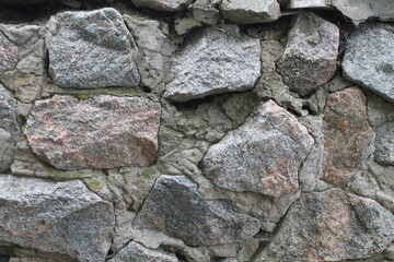 Masonry. A wall of rough large stones. Concrete seams. Old building
