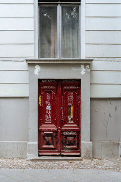 Shabby door of grey building painted with graffiti