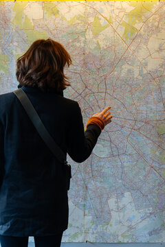 Anonymous tourist studying map of city