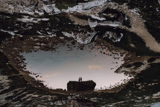 Silhouette Of Couple Reflected In Mountain Lake. Inverted Picture