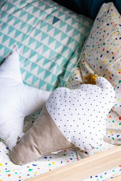 Cute Pillows in Patterns and Shapes on Cild's Bed