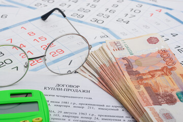 The purchase agreement contains a bundle of money, a calculator and glasses