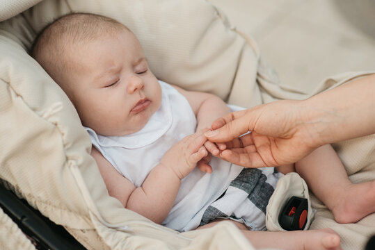 Close up of cute baby sleeping in baby carriage.