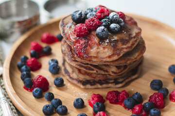 A heap of healthy vegan gluten-free whole grain pancakes made with buckwheat flour topped with...