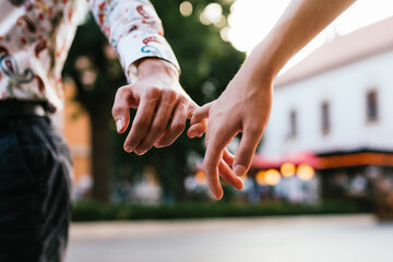Couple holding hands between the fingers.