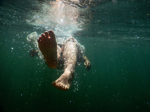 Feet of a woman swimming away