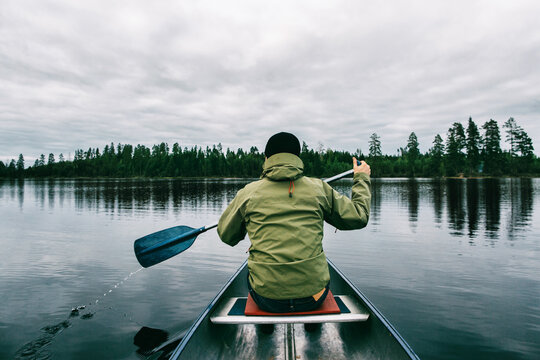 Male Explorer Paddling Canoe