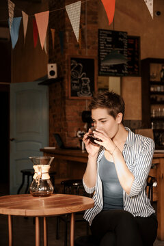 Stylish brunette woman drinking v60 coffee.
