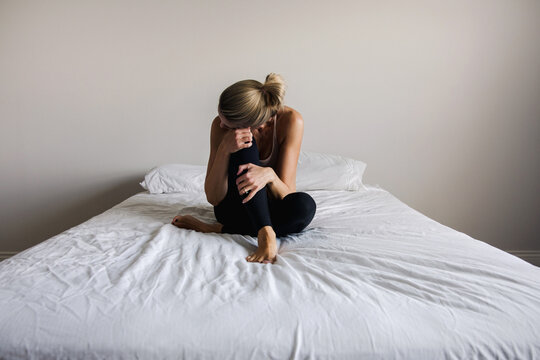 sad woman sitting on a bed