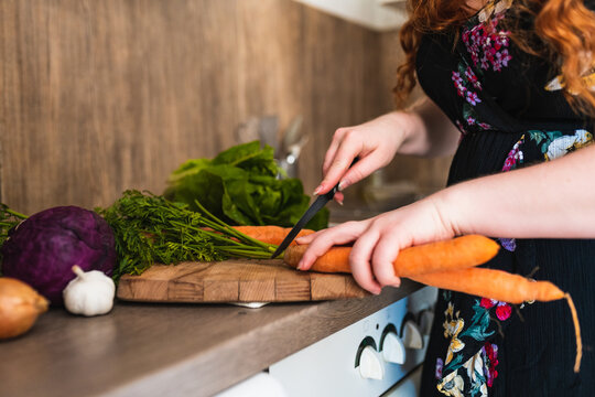 close up of a Woman&not;&yen;s hands cutting off the carrots