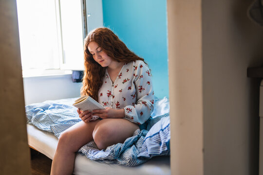 Lovely Red-Haired Female Reading A book in the morning