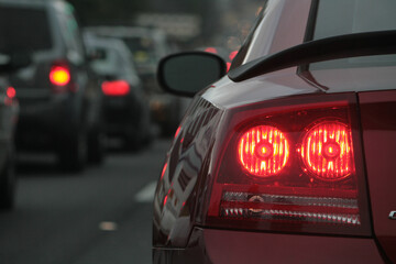 Fototapeta na wymiar A red car with it's brake lights on sits in traffic on highway 280 in Birmingham Alabama