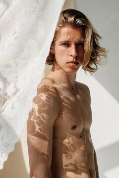 Blond handsome man with floral shadow on his skin