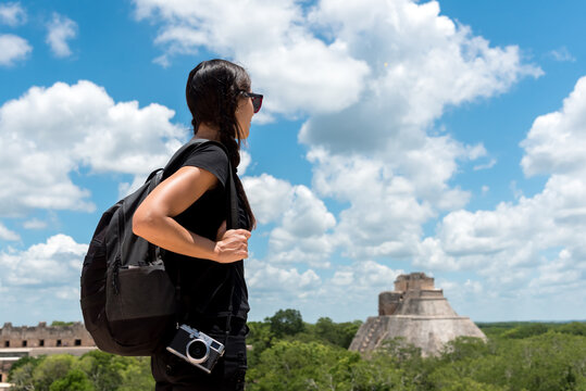 Tourist taking photos of Mayan ruins on the jungle