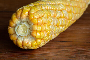 Corn cob on dark wooden rustic background. Detail texture. Macro.
