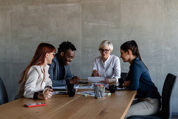 Diverse workers with boss exploring document