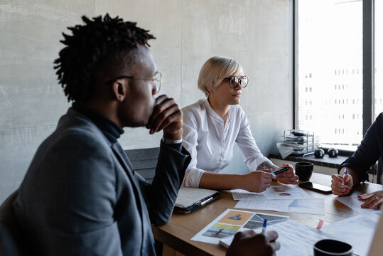 Concentrated multiethnic employees with papers in conference room