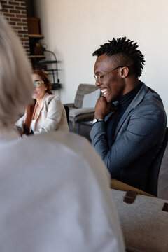 Cheerful African American worker sitting at meeting