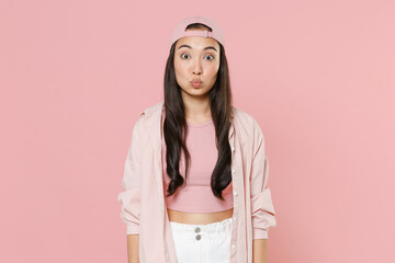 Pretty young asian woman girl in casual clothes cap posing isolated on pastel pink background studio portrait. People emotions lifestyle concept. Mock up copy space. Blowing lips, making duck face.