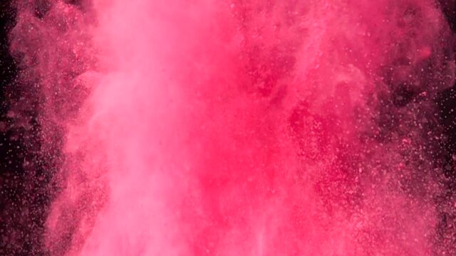 Super slow motion explosion of colorful red powder on dark isolated background