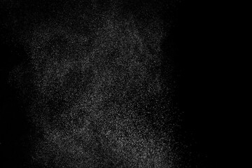 Abstract splashes of water on black background. Freeze motion of white particles. Rain, snow overlay texture.