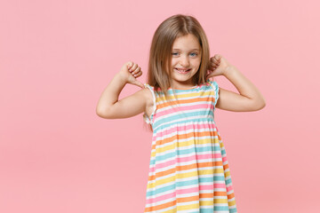Smiling little fun female kid girl 5-6 years old wearing colorful dress blue eyes posing isolated on pink background children studio portrait. People childhood lifestyle concept. Mock up copy space