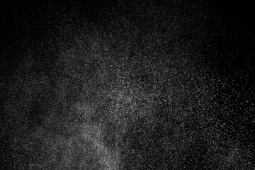 Abstract splashes of water on black background. Freeze motion of white particles. Rain, snow overlay texture.