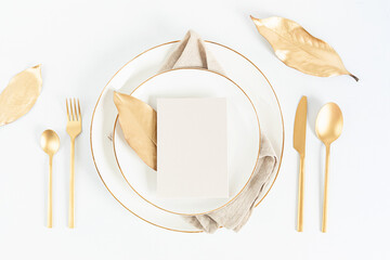 Festive christmas, wedding, birthday table setting with golden cutlery and porcelain plate