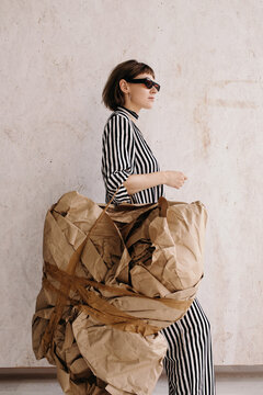 Confident artistic woman carrying abstract baggage